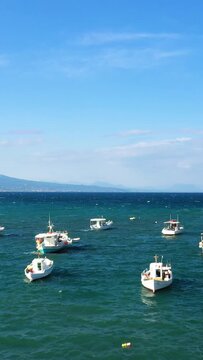 Small fishing boat floating on clear blue water with distant mountains under a bright sky in Koroni, Greece. Peaceful maritime scene ideal for travel and relaxation concepts.