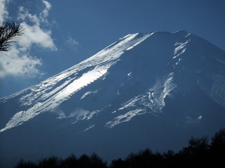 Snow covered Mount Fuji with drifting clouds in winter sky © ぽるる
