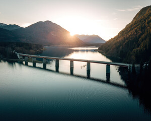 Spectacular Drone View of Sylvenstein Dam and Faller Klamm Bridge, Aerial Autumn Landscape of the Bavarian Alps with Turquoise Water © Joern