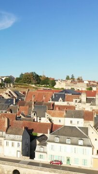 Scenic aerial shot of historic rooftops and buildings in La Charite sur Loire, France, under a clear blue sky. Picturesque architecture and peaceful town atmosphere.