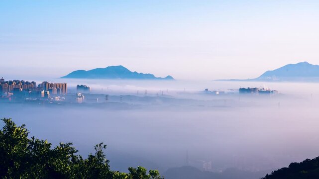 A scenic view of the urban landscape in New Taipei City, Taiwan, shrouded in thick morning mist from Datong Mountain.