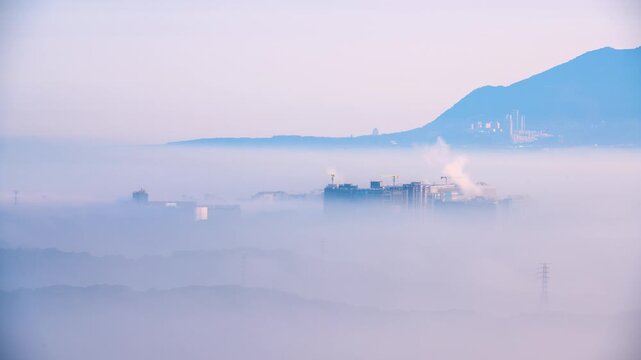 A scenic view of the urban skyline in New Taipei City, Taiwan, partially obscured by thick morning fog, captured from Datong Mountain.