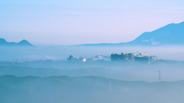 A scenic view of the urban landscape in New Taipei City, Taiwan, partially obscured by morning mist and clouds, viewed from Datong Mountain.