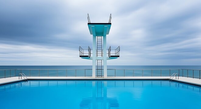 Aqua pool with diving board centered, ocean backdrop, cloudy sky, serene ambiance