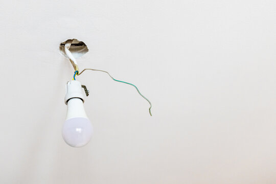 light bulb in electrical socket hangs on ceiling