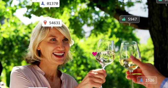 Woman raising wine glass and man joining toast under tree social media icons growing around glasses