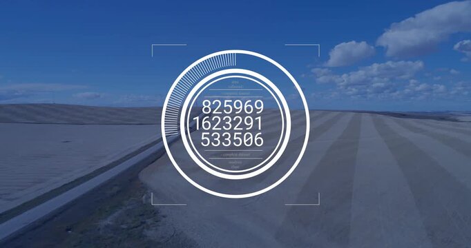 Ringed HUD appearing then cycling numeric readouts for targeting while overlaying canal, sand