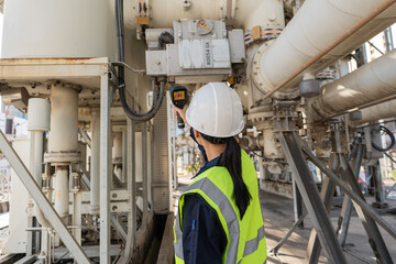 Fototapeta premium Engineer uses a thermal camera to inspect high voltage substation equipment in the energy industry, supporting safety, reliability, diagnostics, and maintenance.