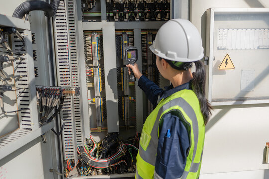 Engineer uses a thermal camera for hotspot detection inside an electrical control cabinet, helping identify abnormal heat, improve safety, support diagnostics, and prevent failure.