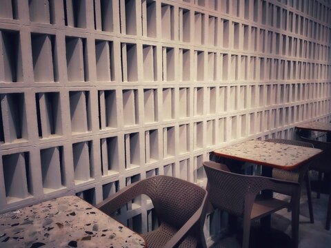 Minimalist Cafe Interior with Geometric Vent Block Wall or Breeze Blocks, and Table Seating