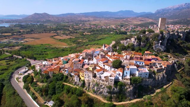 Posada Sardinia aerial view of colorful village on rocks with medieval castle Castello della Fava Italy cinematic drone footage 4k scenic hilltop town landscape travel destination Sardegna island