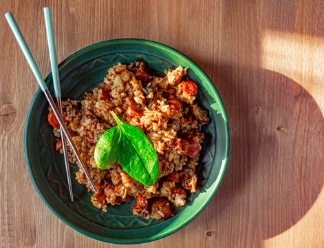 Vegetarian Asian dish with white rice, stir-fried vegetables, and fresh spinach served in a bowl.