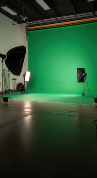 Green screen studio setup with lighting and equipment for video production.