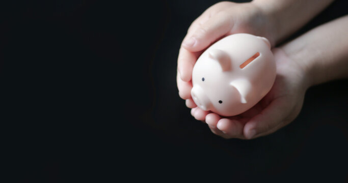 Hands holding piggy bank symbolizing financial protection and personal savings security. Concept of money management, investment planning, economic stability and long term financial safety.