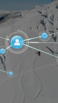 Vertical video: Drone starting, skier skiing while blue icons layering and linking, mapping network