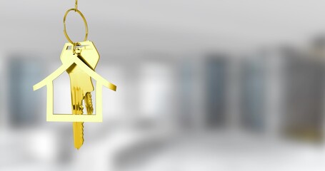 Hanging gold house-shaped keychain holding metal keys in staged flat, with circular metal key ring
