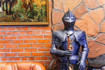 A knight in full armor stands in front of a brick wall © Aleksandr