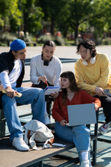 Fototapeta premium Young friends joyfully connect outdoors while sharing ideas under the warm sun