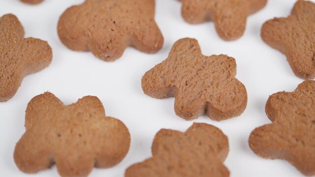 Holiday baking display. Cookies arranged on white surfaces. Gingerbread treats spread on bakery table. Decorative gingerbread cookies placed on various molds and shadows