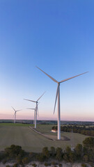 Obraz premium Wind turbines on hill producing renewable energy in countryside landscape