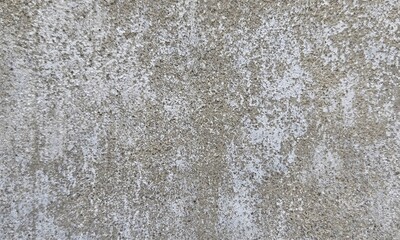 Obraz premium Colorful stains under crumbling gray paint on shabby wall of grungy building on street.Old concrete background for wallpaper.Texture of old dirty Rough Peeled concrete wall for scratched Background.