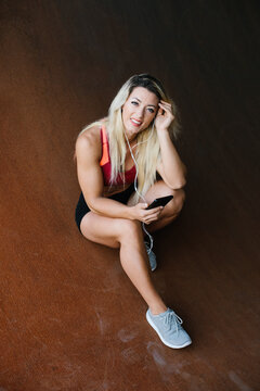 Portrait of a fitness enthusiast taking a break from her outdoor workout to check her phone. Healthy fit lifestyle concept.