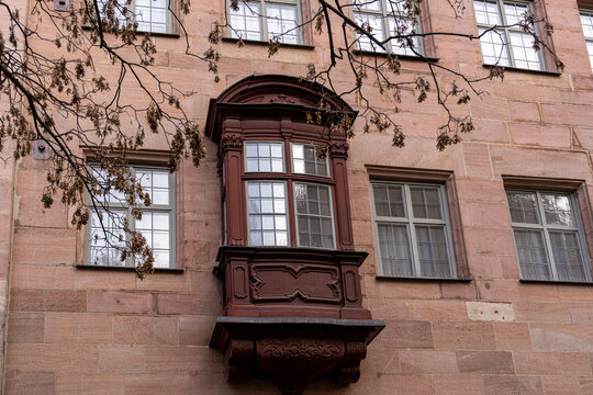 Wooden bay window, called a chorlein, or choir, with pilasters, or columns, on a red stone building in Nuremberg, Germany