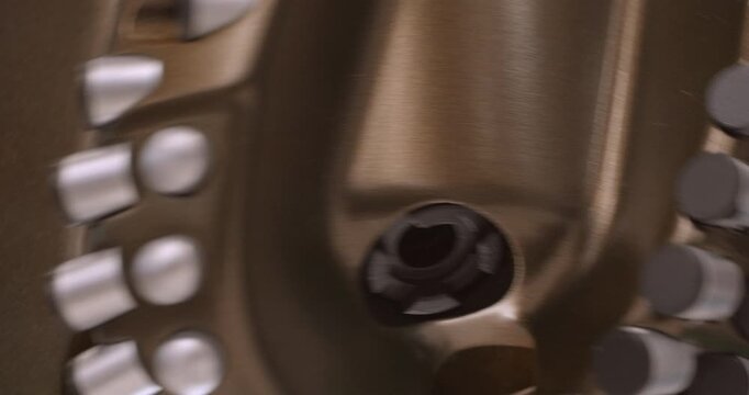 The drilling rig is working. The drill head is rotating. Close-up handheld shot, real time speed, artificial lighting. Abstract industrial background.