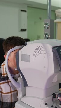 Young man having an eye examination with a keratometer