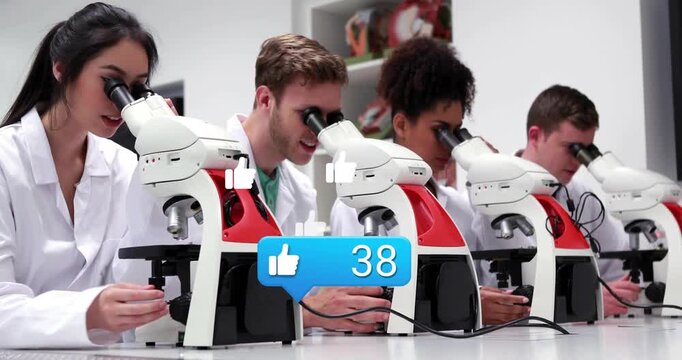 Reacting to overlay, four in lab coats adjusting microscopes at bench for class, with rising thumbs