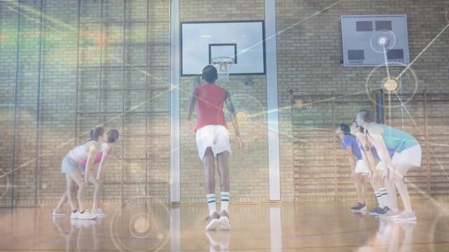 Teen male shooter initiating free-throw in school gym, network overlay tracing ball arc to score