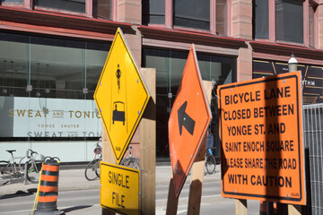 Obraz premium sign at Sweat and Tonic, a fitness centre, located at 225 Yonge St, Floor 1 of The Ryrie Building, incl defocused construction signs, Toronto