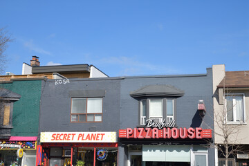 Obraz premium exterior building facade and signs of Secret Planet (918 Danforth) and Danforth Pizza House (920 Danforth), Toronto