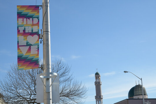 pole mounted banner sign at The Danny, Danforth Av with distant view of Madinah Masjid, Toronto