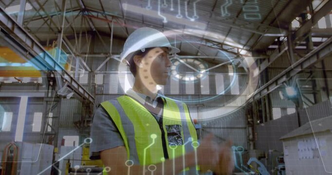 Engineer scanning factory hall and pointing at crane, holographic ring activating for safety check