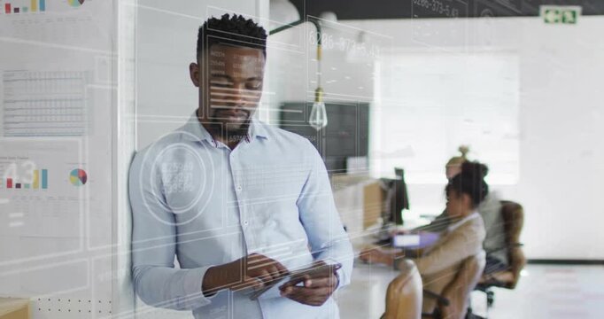 Man tapping tablet and reviewing business data, activating overlay aligning with glass partition