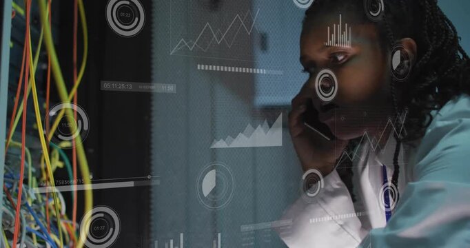 Vertical video: Network tech taking call, troubleshooting rack while monitoring overlays and cables