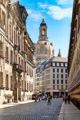 Obraz premium View through narrow street in Dresden to the dome of the Frauenkirche on a sunny day in summer