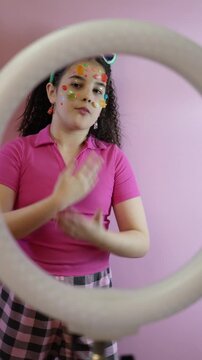 Youthful Makeup Filming. Teenage Girl Recording Makeup Routine With Vibrant Accessories And Lighting
