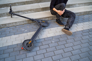 Closeup shot of man fell from electric scooter and injuring his leg © phoenix021
