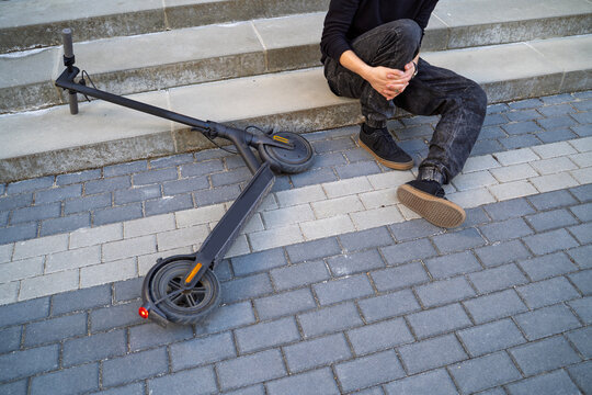 Closeup shot of man fell from electric scooter and injuring his leg
