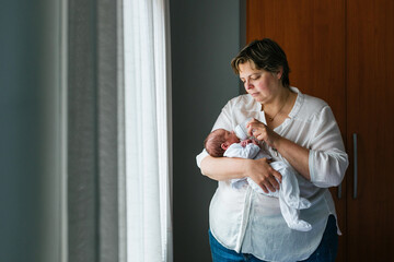 Naklejka premium Mother feeding her one month old baby son with a bottle of milk