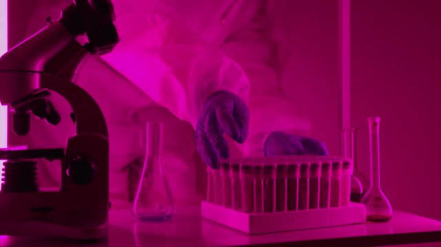 close up of blue liquid being dropped from a pipette into a glass beaker in a chemistry laboratory