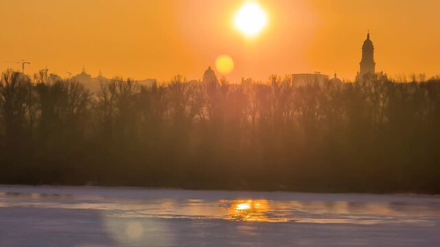 Beautiful sunset view of Kyiv in winter with frozen Dnipro River
