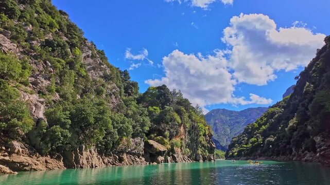 Boat trip on turquoise water of mountain canyon, Verdon Gorge in french Alps, Provence France. Near Aiguines. Canyon is about 25 kilometres long and up to 700 metres deep.