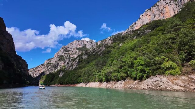 Boat trip on turquoise water of mountain canyon, Verdon Gorge in french Alps, Provence France. Near Aiguines. Canyon is about 25 kilometres long and up to 700 metres deep.