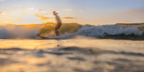 Obraz premium Abstract surfer riding a wave long exposure panorama