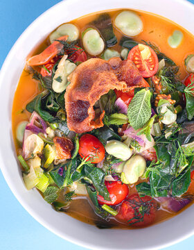Spring minestrone with fava beans and spring vegetables and herbs, close up