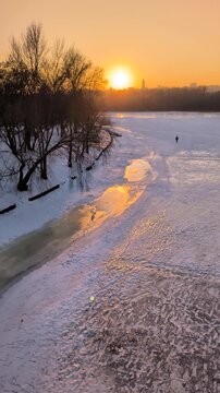 Beautiful sunset view of Kyiv in winter with frozen Dnipro River