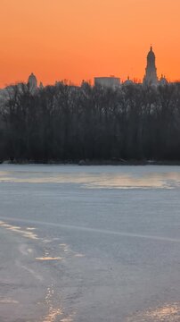 Beautiful sunset view of Kyiv in winter with frozen Dnipro River